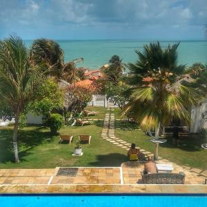 卡诺格布拉达瓦尔卢艾尔旅馆的享有棕榈树和大海的度假庭院的景色