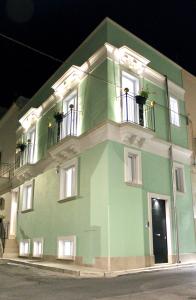 格罗塔列Domus Le Ceramiche的绿色建筑,设有两个阳台,位于街道上