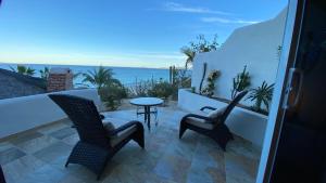 La Ventana温塔娜湾度假酒店的阳台配有两把椅子和一张桌子,享有海景。