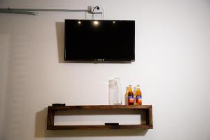 萨卡特兰Casa Iztac的墙上的平面电视,书架上装有瓶子
