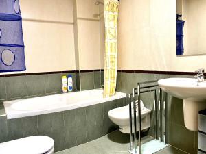 莱昂Housingleón - Centro con dos plazas de garaje的浴室配有盥洗盆、卫生间、浴缸和盥洗盆。