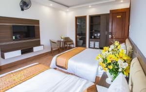 岑山Tan Truong Son Legacy Hotel的酒店客房带两张床和花瓶