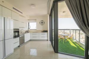 耶路撒冷Gorgeous Design 3 BDR Appart - J Tower - Amazing View!的一间厨房,配有白色的橱柜和大窗户