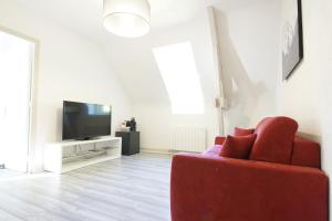 Lassay-sur-CroisneDomaine Providence的客厅配有红色沙发和电视
