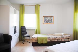 萨斯尼茨菲尔韵朗知外斯迈公寓酒店的一间卧室配有两张床、一张桌子和一把椅子