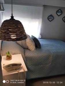 埃斯特角城Apartamento Marina de roosvelt con piscina climatizada的一间卧室配有一张带桌子和台灯的床