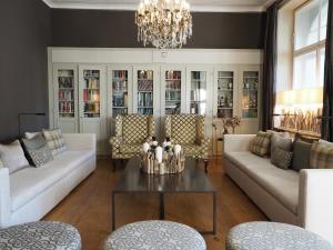 达沃斯雪绒花酒店的客厅配有白色家具和吊灯。