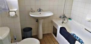 克拉伦斯Charmwood的浴室配有盥洗盆、卫生间和浴缸。