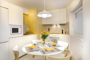 潘蒂科萨Loft Casa Berdon的白色的厨房配有白色的桌子和椅子