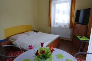库多瓦-兹德鲁伊Apartamenty u Ani的一间卧室配有一张床和一张鲜花桌子