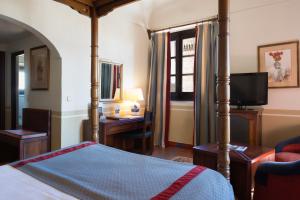 奥罗佩萨奥罗佩萨酒店的一间卧室配有一张床、一张书桌和一台电视