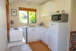 箭镇Arrowtown Country Cottage的厨房配有白色冰箱和微波炉