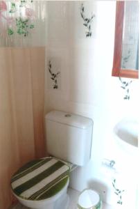 大伊瓜巴Apartamento Iguaba Grande, bairro Canellas City , em frente ao trailer do popeye的浴室配有白色卫生间和盥洗盆。