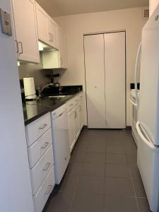 波士顿Central Chinatown 30 Day Stays的厨房配有白色橱柜和白色冰箱。