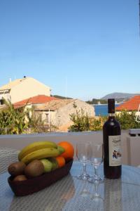 尼基亚娜Pantazis Studios的一张桌子,上面放着一碗水果和一瓶葡萄酒