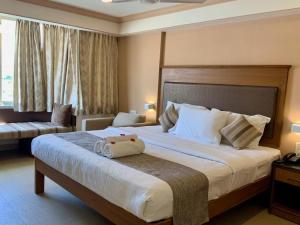 普塔帕蒂Sai Towers的酒店客房设有一张大床和一张沙发。