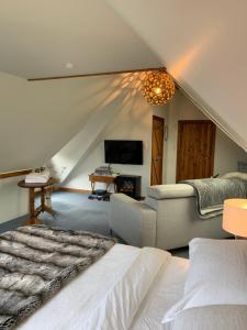 纳尔逊Quail Farm, Colonial charm的一间卧室配有一张床、一张沙发和一台电视。