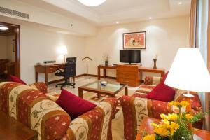 钦奈雅阁大都会饭店的客厅配有沙发和桌子