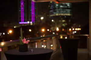 马尼拉Wynwood Hotel的一张桌子,晚上在阳台上放着鲜花