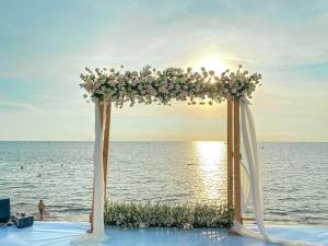 富国富国贝壳酒店及Spa的海滩上鲜花盛开的婚礼拱门