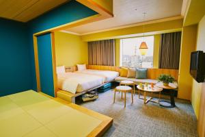 旭川OMO7 Asahikawa by Hoshino Resorts的酒店客房,配有床和沙发