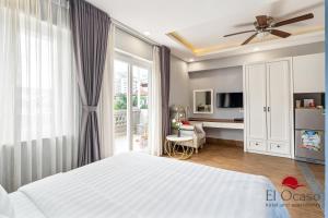胡志明市El Ocaso Hotel and Apartments的一间带白色床的卧室和一间客厅