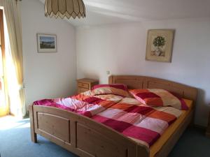 基姆湖畔布赖特布伦Ferienhaus Seiderer的一间卧室配有一张带五颜六色棉被的木床