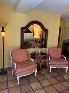 棕榈泉La Maison Hotel - Adults Only的一间设有两把椅子、一张桌子和一面镜子的房间