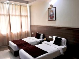 瑞诗凯诗Hotel Trihari的酒店客房,配有两张床和椅子