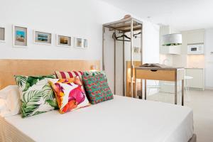 科尼尔-德拉弗龙特拉Apartamentos y estudios céntricos Conil Home Suite的卧室配有白色的床和色彩缤纷的枕头