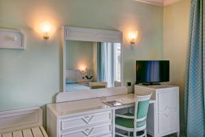 索伦托里维耶拉大酒店的客房设有一张带电视和镜子的书桌