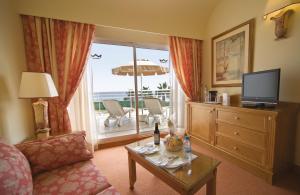 科拉雷侯Hotel Riu Palace Tres Islas的带沙发和电视的客厅以及阳台。