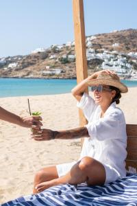 迈洛波塔斯狄俄尼索斯海滨度假酒店的坐在沙滩椅上的女人