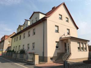 RoßlebenFerienwohnung Hendrich Roßleben的街道边的白色大建筑