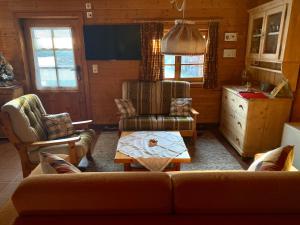 萨沃宁Chalet Wulli in der Nähe der Skianlagen Savognin的客厅配有沙发、椅子和桌子