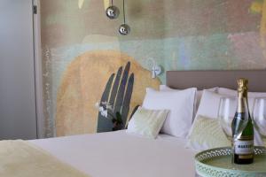 米萨诺阿德里亚蒂科Hotel Alexandra - Beach Front -XXL Breakfast & Brunch until 12 30pm的一间卧室配有一张带两瓶香槟的床