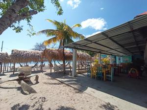 普拉亚布兰卡NICO'S BEACH PANAMA的海滩上设有凉亭和桌椅