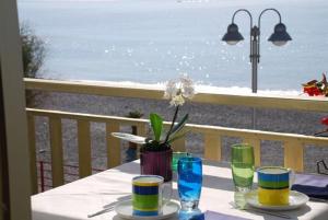 博尔迪盖拉小天堂酒店的海滩阳台上的桌子,上面有盘子和玻璃杯
