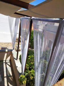 埃尔莫波利斯maria's rooms syros的庭院上设有白色窗帘的窗户