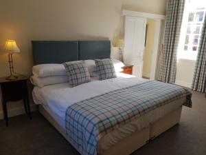 MayboleRoyal Artillery Cottage - Culzean Castle的一间卧室配有一张带蓝色床头板和枕头的床。
