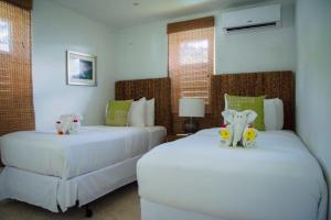 BequiaBequia Plantation Hotel的一间卧室设有两张床,里面饲养着动物。