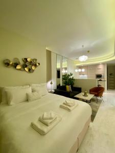 麦纳麦Bahrain bay studio的一间带白色大床的卧室和一间客厅