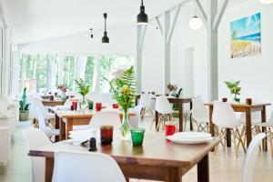 斯蒂格纳Ośrodek Wypoczynkowy Cubex的配有木桌和白色椅子的餐厅