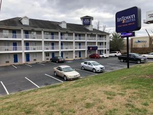 查塔努加InTown Suites Extended Stay Chattanooga TN - Hamilton Place的停车场内有车辆的旅馆