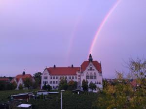 梅森Ferienwohnung Burkhardt的一座白色的建筑上方的彩虹