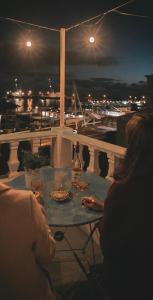 蓬塔德尔加达Casa Vista Marina的一位晚上坐在阳台上桌子上的女人