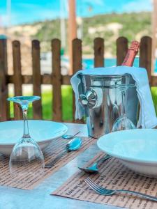 梅加尼西岛Mistral Boutique Hotel的一张桌子上放有盘子和酒杯