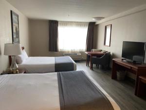 塞勒姆塞勒姆希洛酒店套房的酒店客房设有两张床、一张桌子和一台电视。