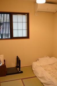 京都东山之宿 缘侧的一间卧室设有一张床和一个窗口