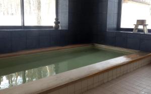 白马村双黑酒店的浴室设有装满水的浴缸。